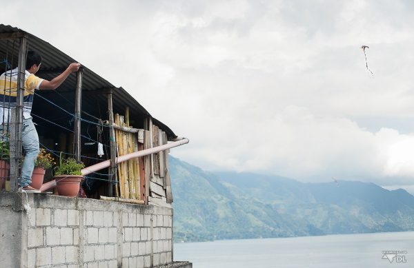 Les nombreux enfants qui jouent au cerf-volant avec la vue sur le lac Atitlán