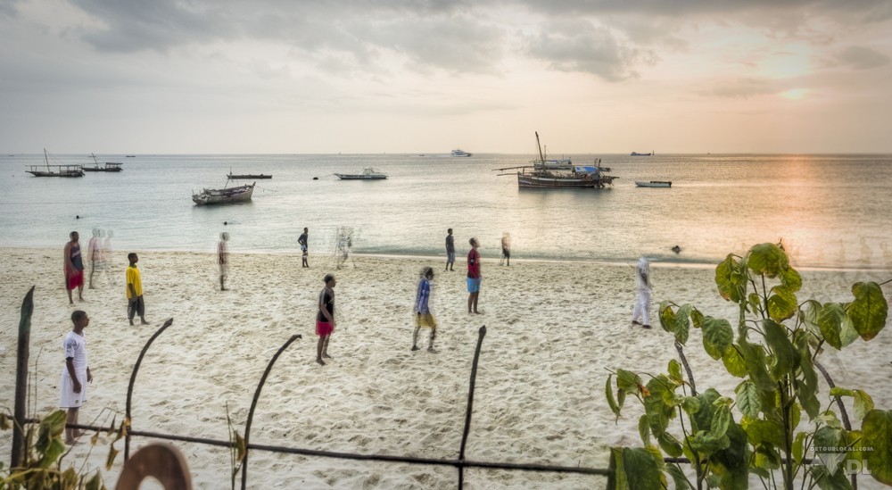 Au coucher du soleil les locaux s'activent sur la plage près du ferry de Zanzibar