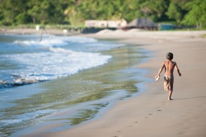Petit tout nu qui court à la recherche d'un poisson sur la plage Marsella, Nicaragua